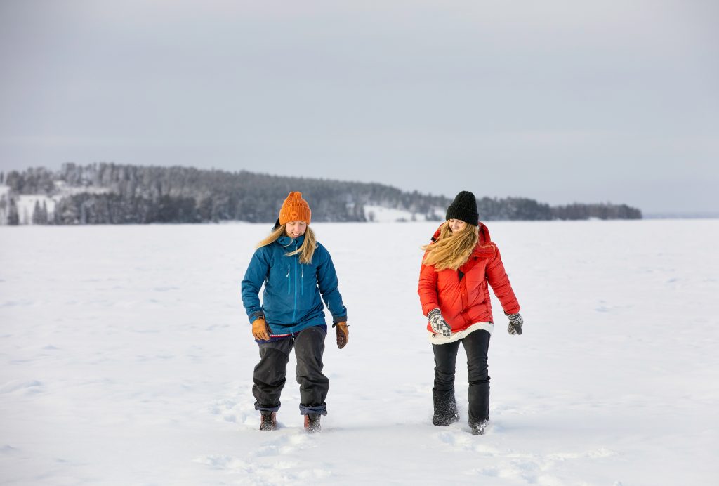 Välj äventyret i Jämtland Härjedalen. Två personer prommenerar på snötäckt sjö.